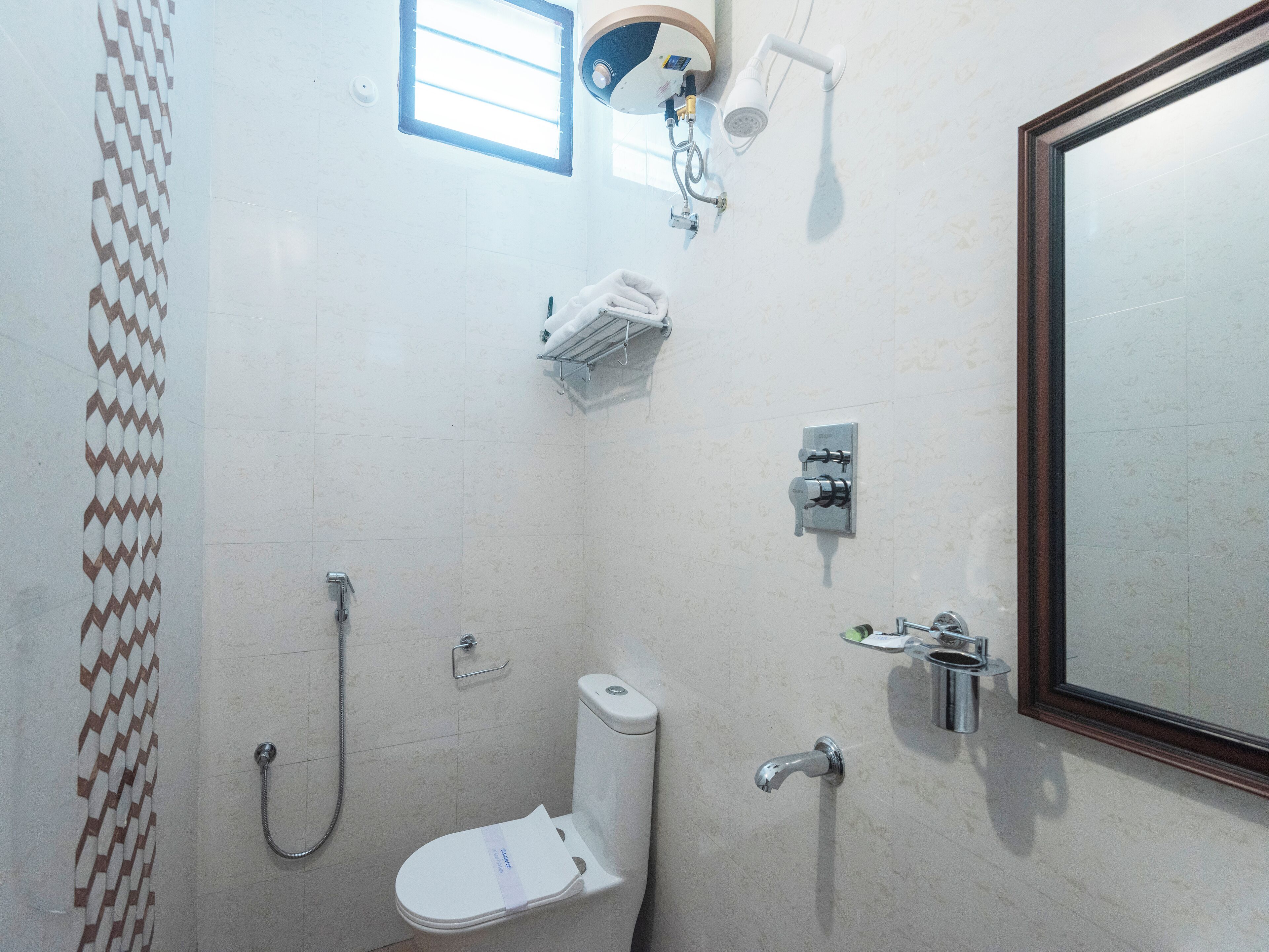 A small bathroom with a toilet, a shower, and a mirror.
