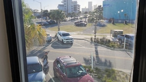 Um estacionamento com vários carros e um edifício ao fundo.
