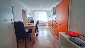 A modern kitchen with wooden cabinets, a dining area with a bench, and a view of the outdoors through a window. - Good prices Good travel, 4 bedrooms and 2 bathrooms on 130sqm (Neuried)