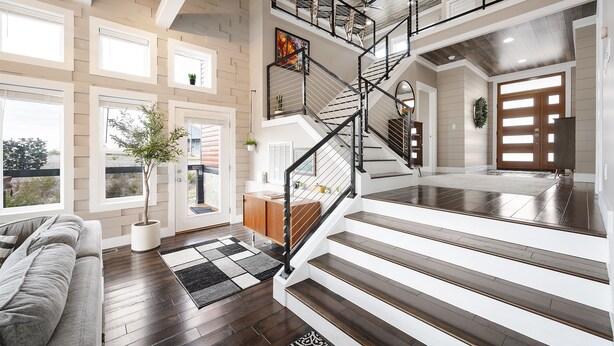 Un amplio espacio de estar con una escalera, un sofá y una planta en maceta.
