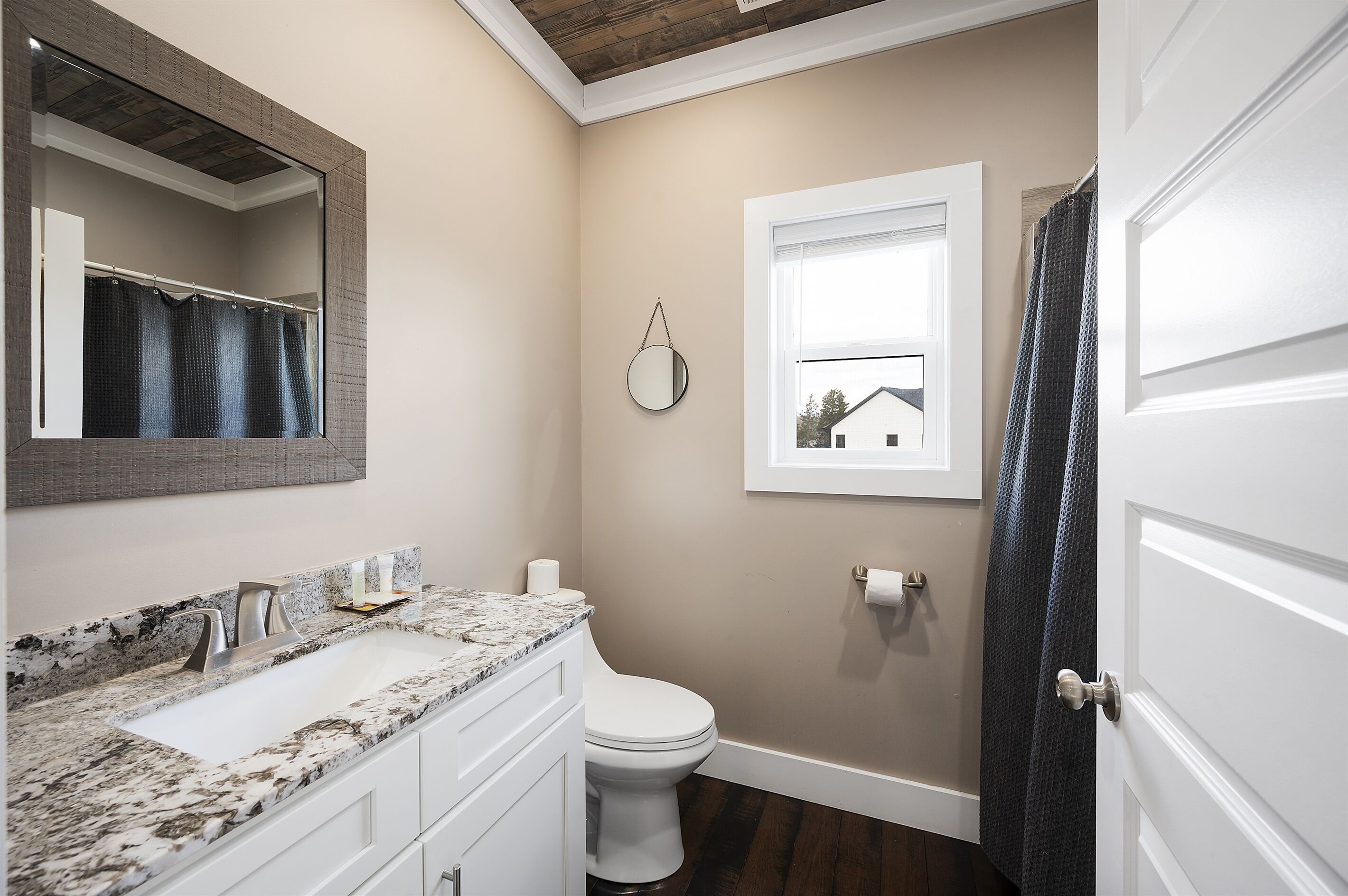 A bathroom with a white sink, mirror, and toilet.