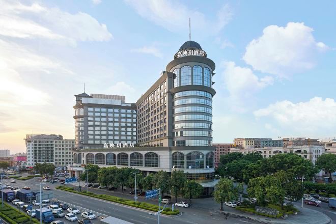 A multi-story hotel with a prominent curved tower and a large central building.