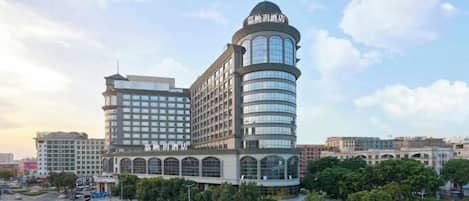 A multi-story hotel with a prominent curved tower and a large central building.
