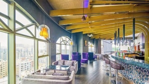 A modern bar area with seating, large windows, and a city view. - Joyc Hotel Dongguan (Dongguan)