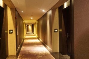 Pasillo de hotel con puertas numeradas 1207 y 1208, que dan a las habitaciones.