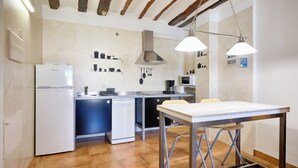 A modern kitchen with a refrigerator, dishwasher, and a dining table with chairs. - San Francisco 58  (Santo Domingo de la Calzada)