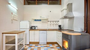 A compact kitchen with white cabinets, a microwave, a dishwasher, a stove, and a checkered floor. - San Francisco 58  (Santo Domingo de la Calzada)