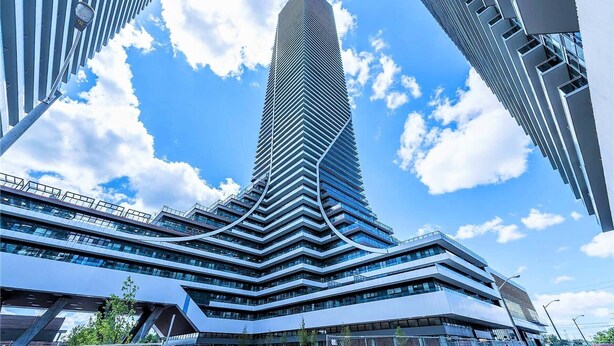 Un grattacielo moderno dal design originale e a torsione, circondato da altri edifici alti.