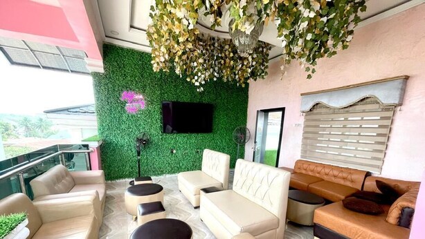 Un espace de détente moderne avec des canapés, un téléviseur et un mur végétal.