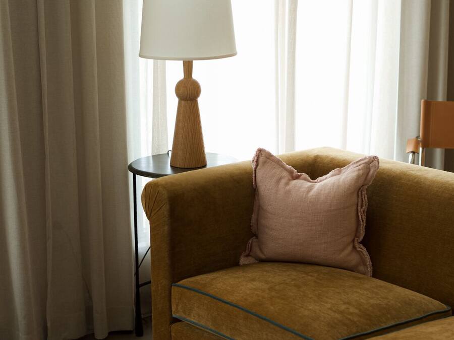 Une pièce avec un canapé, une lampe et un fauteuil.