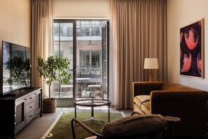 Suite, 1 très grand lit, balcon | Aire de séjour | Téléviseur connecté de 65 po avec télévision par câble, Netflix, Hulu