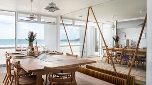 Ein Essbereich mit Meerblick, Holzmöbeln und modernem Interieur.