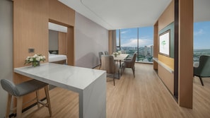 Ein modernes Hotelzimmer mit großem Fenster, einer Essecke und einem Bett.