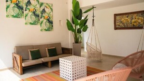 A modern living room with a sofa, a hanging chair, a potted plant, and artwork on the walls. - Palma Dorada (Tucacas)