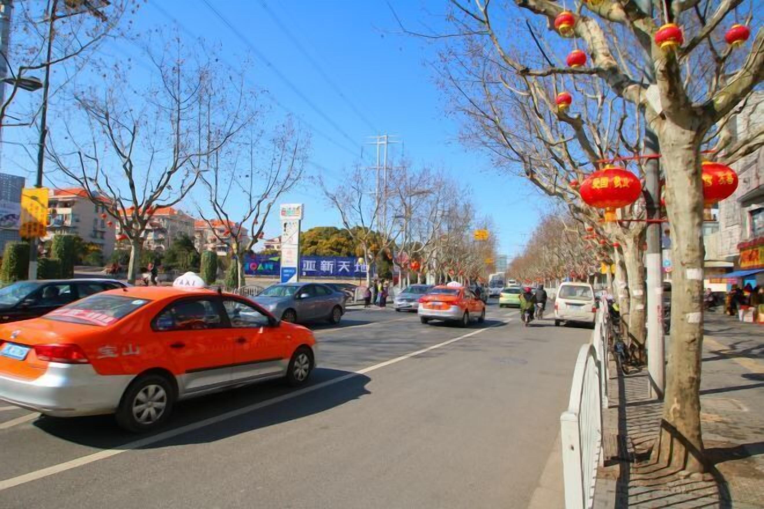 A street scene with cars, trees, and buildings.