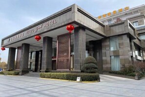 Un hotel moderno con una entrada destacada, amplias columnas y un exterior bien conservado.