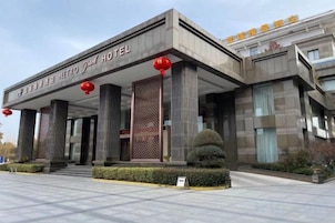 Un hotel moderno con una entrada destacada, amplias columnas y un exterior bien conservado.