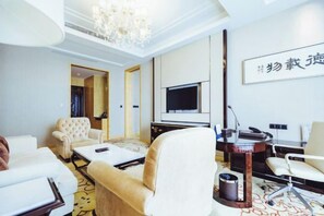 A hotel room with a sofa, armchairs, a TV, a desk, and a chandelier. - Metropark Hotel Yancheng (Yancheng)