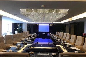 A conference room with a long table, chairs, and a large screen. - Metropark Hotel Yancheng (Yancheng)