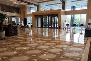 A spacious lobby with a geometric tile floor, large windows, and a reception desk. - Metropark Hotel Yancheng (Yancheng)