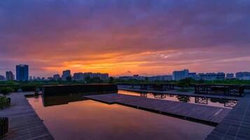 Vista al agua con un muelle de madera y una superficie acuática tranquila que refleja el cielo.