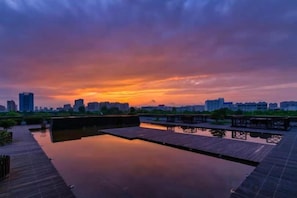 Vista al agua con un muelle de madera y una superficie acuática tranquila que refleja el cielo.