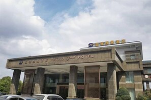 Un hotel con una entrada destacada, grandes pilares y un cartel que indica que es el Metro Grand Hotel.
