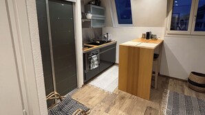 Une cuisine compacte avec un coin repas, une porte-fenêtre coulissante et une petite fenêtre.