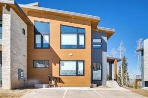 A modern two-story building with large windows, a wooden facade, and a concrete driveway. - Modern Ski-In/Out Home in Brian Head w/ Deck (Brian Head)