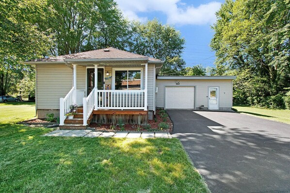 A single-story house with a front porch, a garage, and a well-maintained lawn.
