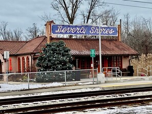 A train station named Beverly Shores with a Christmas tree and a sign indicating south shore parking.