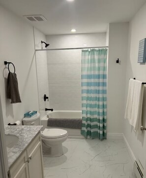 Regadera, secadora de cabello, toallas, papel de baño
