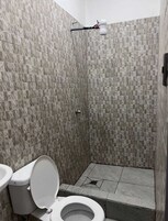 Bañera con ducha, toallas, jabón, shampoo