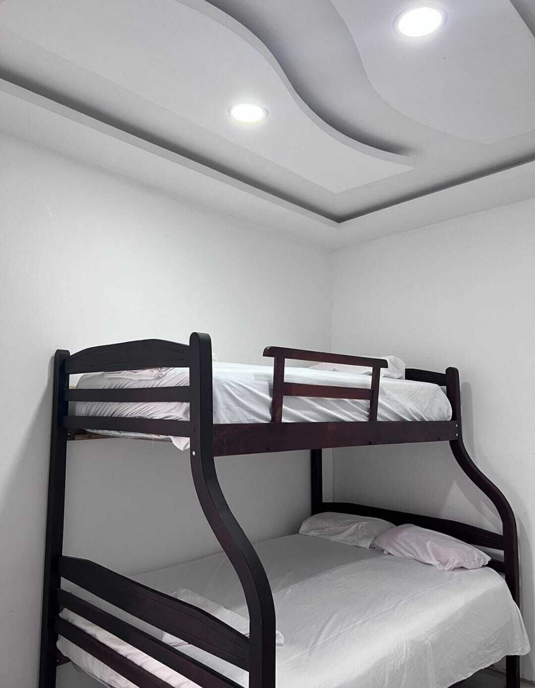 A bunk bed room with white walls and a curved ceiling design.