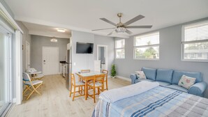 A bedroom with a bed, a ceiling fan, a TV, a dining table with chairs, and a window with blinds. - 5 Mi to Beaches: Melbourne Duplex w/ Heated Pool! (Melbourne)