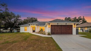 A single-story house with a garage, a driveway, and a well-maintained lawn.