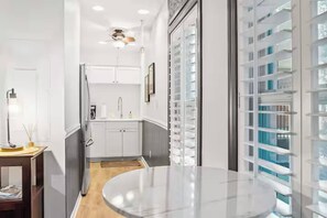 A modern kitchen with white cabinets, a built-in oven, and a round marble countertop. - Cozy Riverside Retreat (Wilmington)