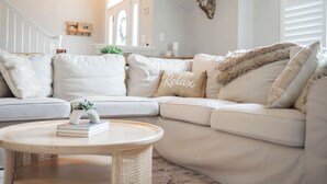 A modern living room with a sectional sofa, a round coffee table, and a decorative deer head on the wall. - Captains Quarters in Charming Lewes! (Lewes)