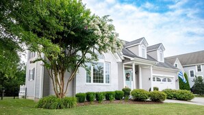 A two-story house with a front porch, a garage, and a well-maintained lawn. - Captains Quarters in Charming Lewes! (Lewes)