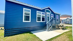 A small, single-story building with a blue exterior, white trim, and a front porch with a staircase. - New Listing! Mins to Beach*2 Bdrm*Sleeps up to 6 (Bolivar Peninsula)