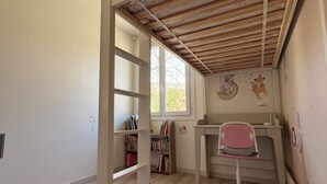 Una habitación infantil con una litera, un escritorio y una silla.