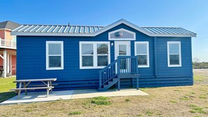 A small, single-story blue building with a porch and a staircase. - Pet Friendly*Near Beach & Margaritaville (Bolivar Peninsula)