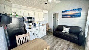 Un espacio habitable compacto con cocina, comedor y zona de estar.