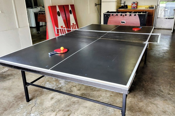 Ping pong table, foosball and corn hole in garage