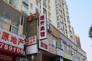 A multi-story building with commercial signage, including a prominent red sign for a real estate agency and a white sign for a business. - Jiaqi Hotel (Shanghai)