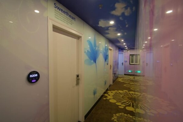 A hotel corridor with a floral carpet, a digital clock, and a wall with a 'Sweetheart' sign. - Jiaqi Hotel (Shanghai)