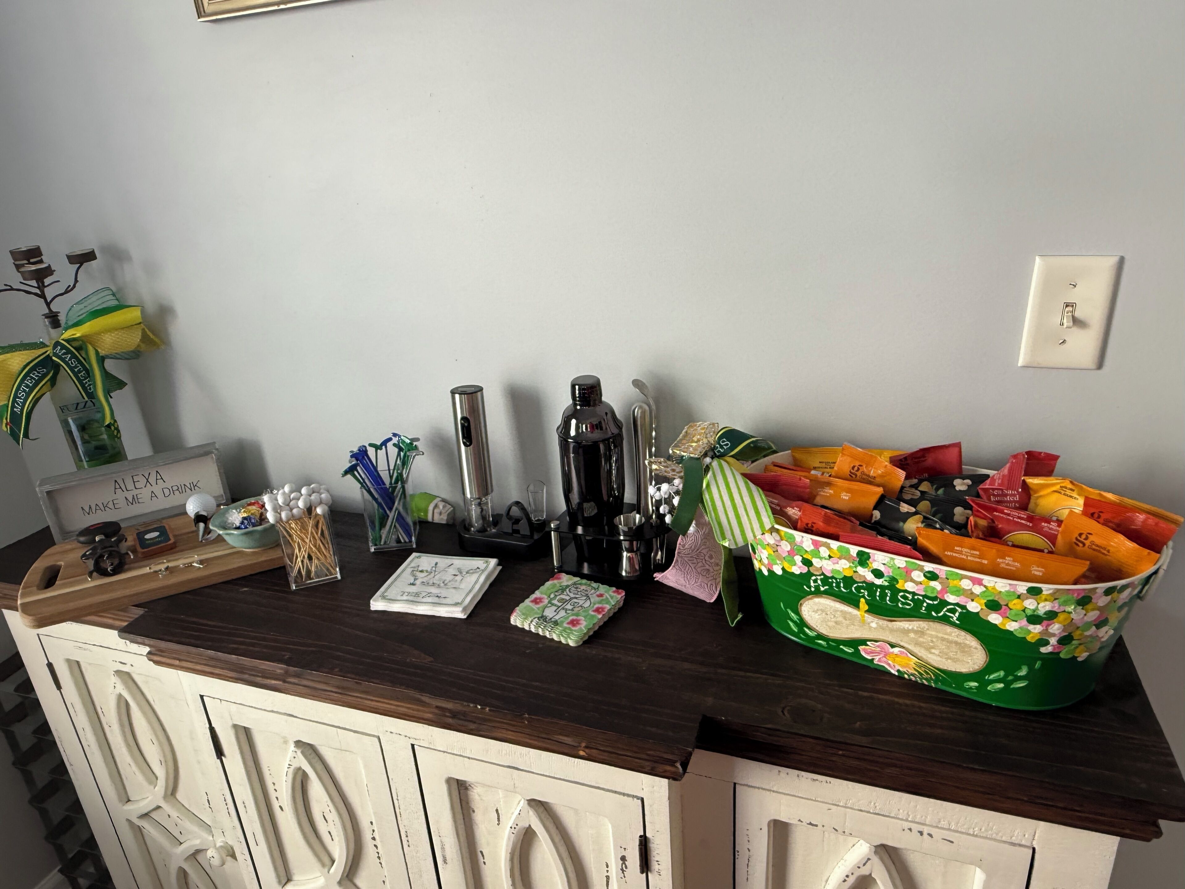 A kitchen counter with a coffee maker, a tray, a card, and a bowl of snacks.