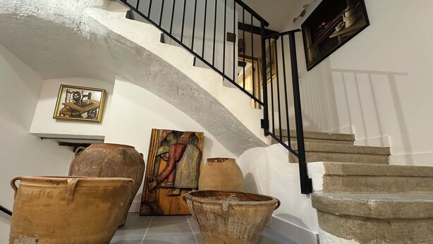 A staircase with a black railing leading to an upper floor. There are several large terracotta pots on the floor near the stairs. - CASA RURAL LAS MARIPOSAS A HOUSE FULL OF HISTORY TO RELAX IN NAVARRE (Lerín)