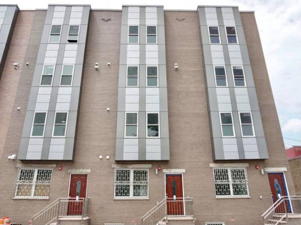 A multi-story building with a consistent facade, featuring rectangular windows and doors.