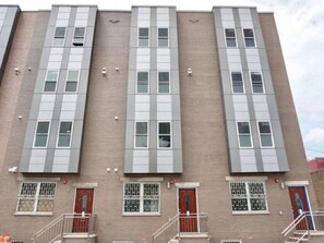 Un edificio de varios pisos con una fachada uniforme, con ventanas y puertas rectangulares.